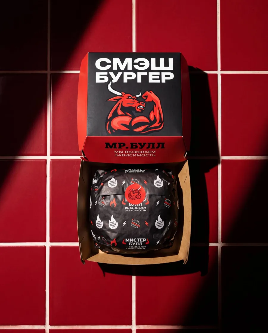 Фирменная коробка «Смэш бургер» Мистер Булл с надписью «Мы вызываем зависимость» и бургер в обёртке